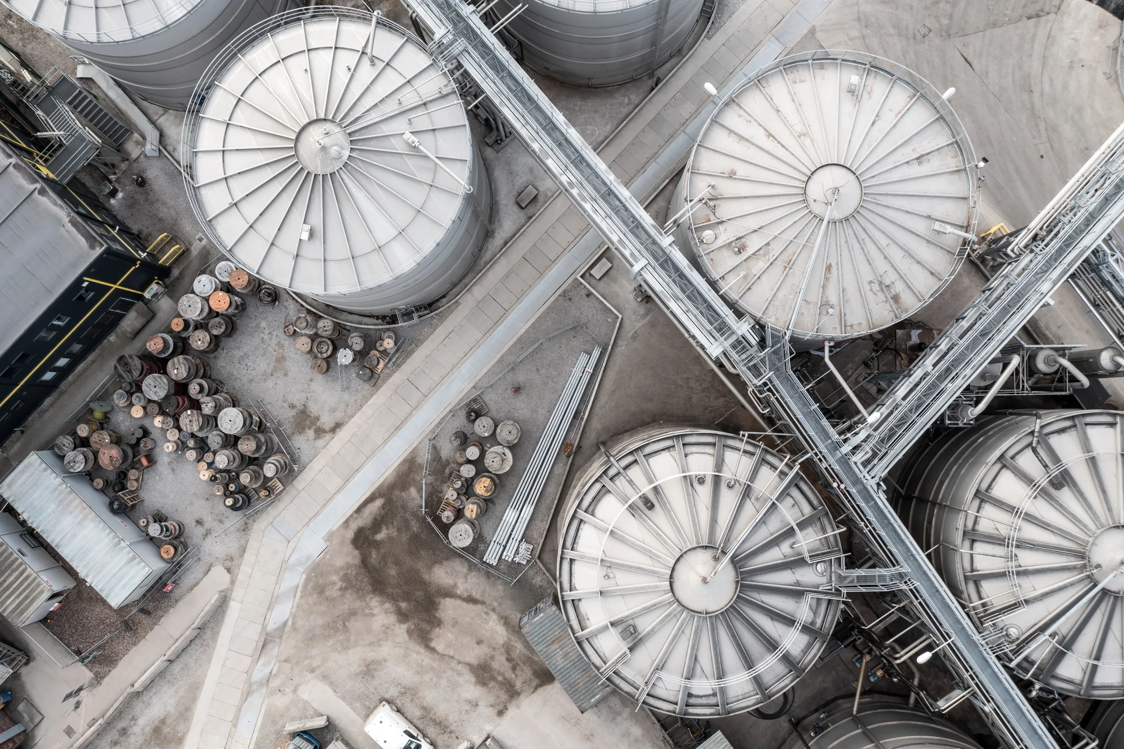 Overhead view of industrial storage tanks, connecting pipework and access routes.