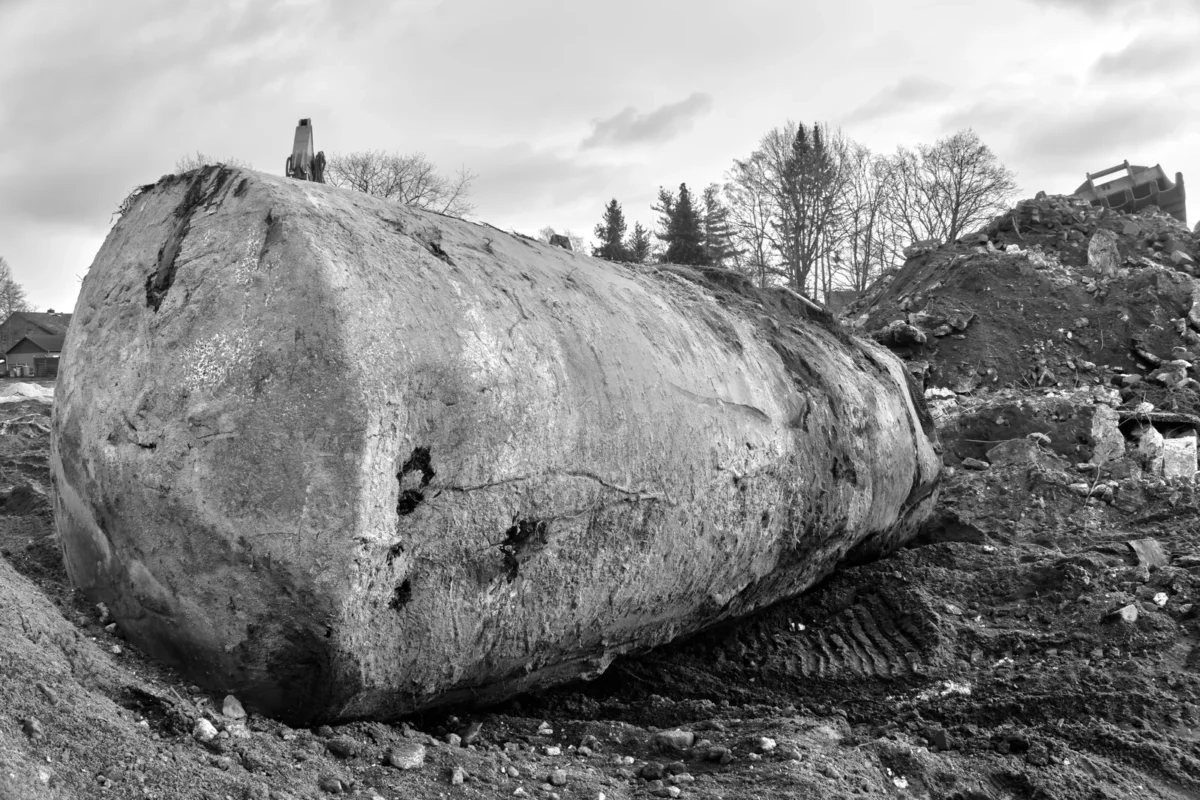 Excavated underground fuel tank exposed for removal from a site.