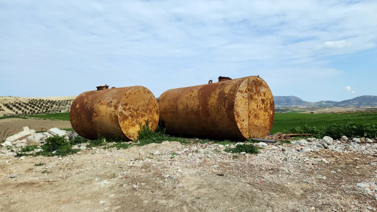 Removed steel fuel storage tanks in an outdoor work area.